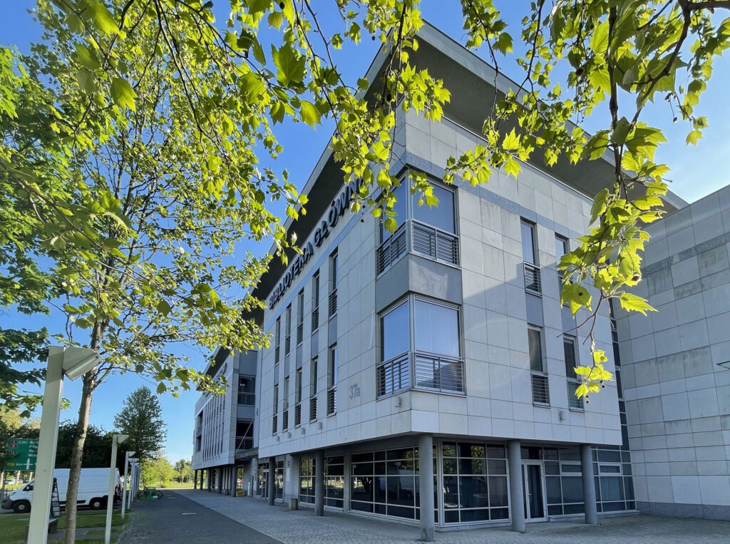 Biblioteka Główna UMP - front budynku z perspektywy narożnika, ulica przed budynkiem. Wiosna.