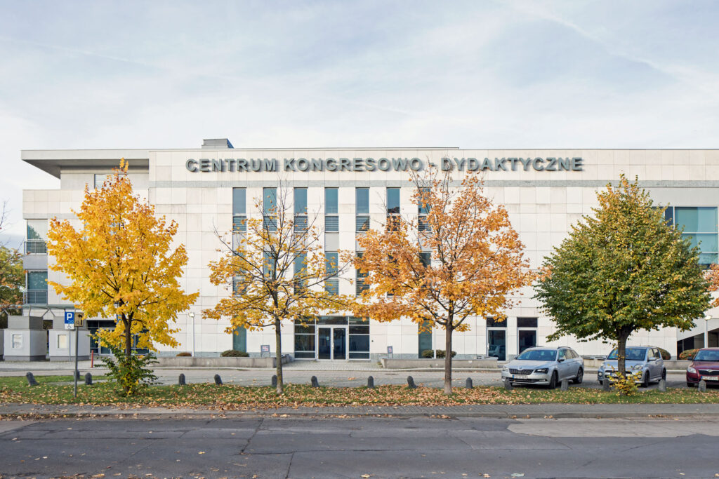 Biblioteka Główna UMP - boczna ściana dwupiętrowego budynku. Na górze budynku napis Centrum Kongresowo-Dydaktyczne. Jesień.