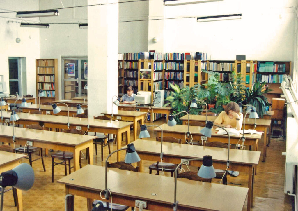 Biblioteka, ul. Parkowa, czytelnia studencka, pod ścianą regały z książkami, na pierwszym planie stoliki i krzesła.